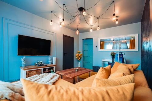 a living room with a couch and a tv at Ilmar suites - new in Cluj-Napoca