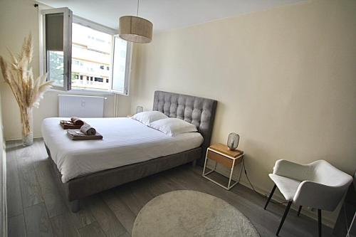 a bedroom with a bed and a chair and a window at Pied-à-terre - Apartment 75m2 - free parking in Oullins