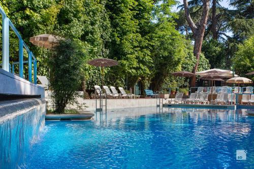 a swimming pool with chairs and umbrellas in a resort at Aldrovandi Residence City Suites in Rome