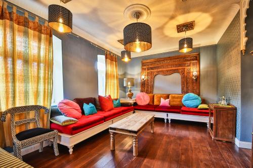 a living room with a red couch with colorful pillows at Bio-Hotel Villa Waldfrieden in Bad Schandau
