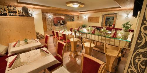 a restaurant with a long table and chairs at Hotel Duc De Rohan in Livigno
