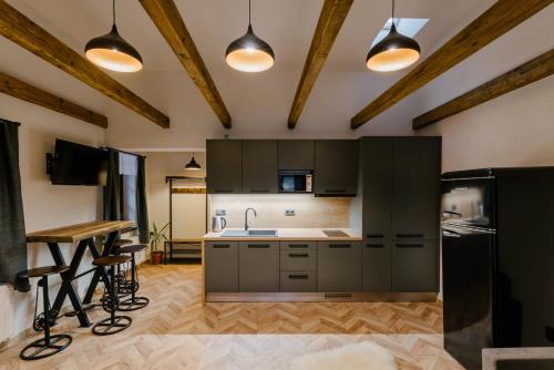 a kitchen with black cabinets and a table and chairs at Kamenná stráň in Metylovice