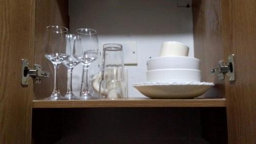 - une étagère avec des verres à vin et des assiettes dans l'établissement A Fully Budget premium Studio, à Nairobi