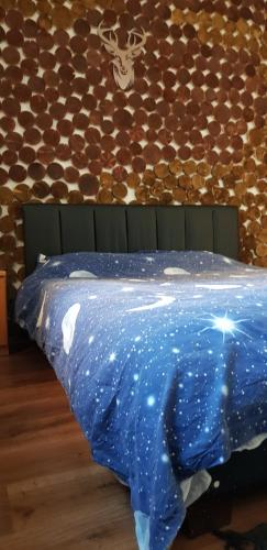 Una cama con un edredón azul con estrellas. en Straja Apartament, en Lupeni
