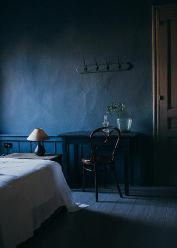 a blue room with a chair and a table with a bed at 1900 Hotel in Symi