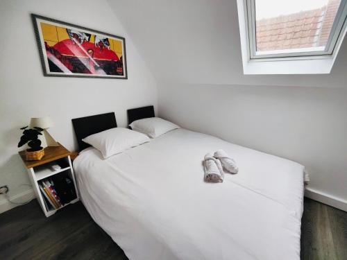 une chambre avec un lit blanc et une fenêtre dans l'établissement Studio passage des arts - Vieux Lille, à Lille