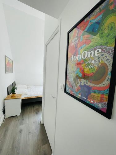 a large poster hanging on a wall in a room at Passage des arts - Vieux Lille - 2 personnes in Lille