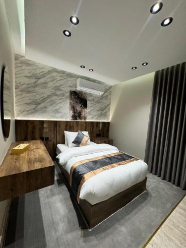 a bedroom with a large bed and a desk at Medad Apartments Al Hamra in Al Khobar