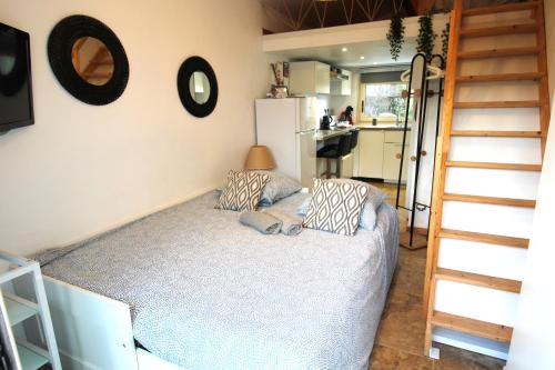 a bedroom with a bed and a staircase in a room at Les Bastidons de L'Isle - st ju- 3 étoiles in LʼIsle-sur-la-Sorgue