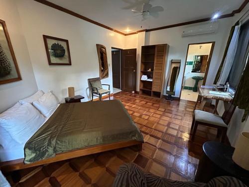 a bedroom with a bed and a chair in a room at Argonauta Boracay Apartment Suites and Villas in Boracay