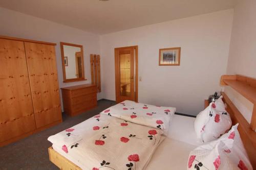 - une chambre avec 2 lits et des draps fleuris dans l'établissement Haus Christophorus, à Bad Gastein