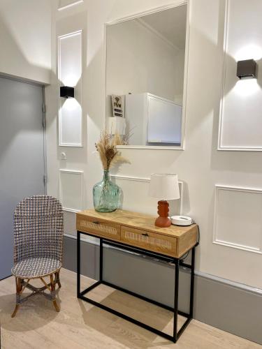 une table avec une lampe et une chaise dans une pièce dans l'établissement Studio Cosy Le Bareuzai, à Dijon