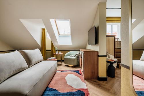 a living room with a couch and a tv at Colette - LoftAffair Collection in Warsaw