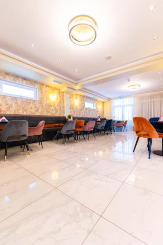 a large room with chairs and tables in it at Dinasty Hotel in Sîntana
