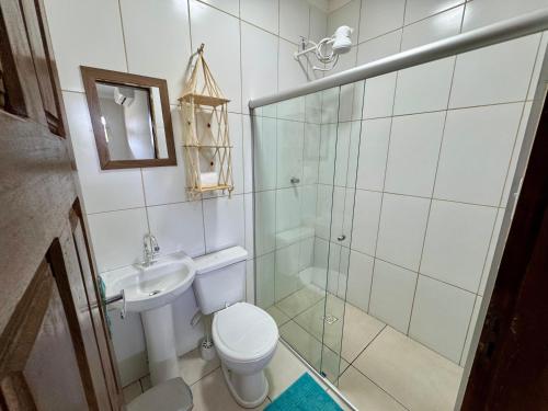 a bathroom with a shower and a toilet and a sink at Pousada e Restaurante Cenário in Marau