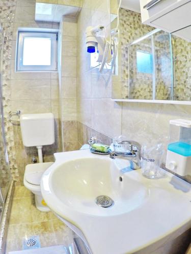 a bathroom with a white sink and a toilet at Apartments Pravica Trebinje in Trebinje