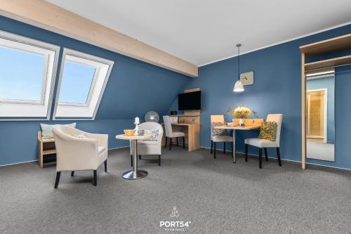 a dining room with blue walls and tables and chairs at Ferienwohnung Bude 5 Dagebüll in Dagebüll