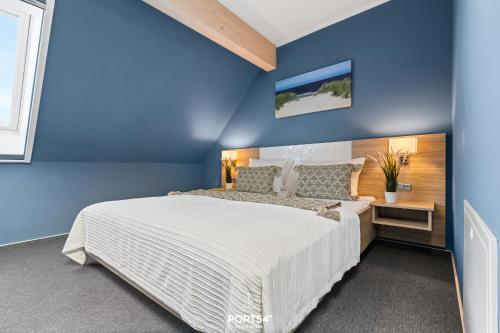 a bedroom with blue walls and a large bed at Ferienwohnung Bude 6 Dagebüll in Dagebüll