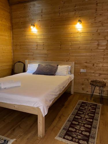 a bedroom with a bed in a wooden wall at Cabana Izvorul Rece Maramureş in Baia-Sprie