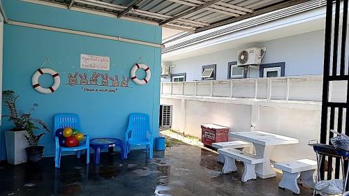 a room with two blue chairs and a table at Baanpeanutsvilla Huahin in Hua Hin