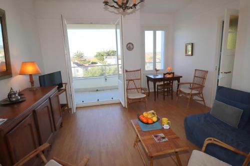 un salon avec un canapé bleu et une table dans l'établissement Le Bellevue Building by Tranquil at Home, à La Baule