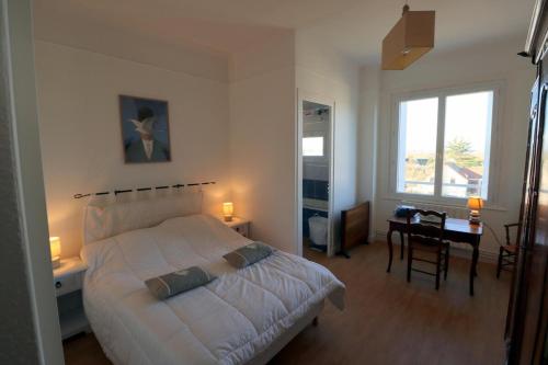 une chambre avec un lit, un bureau et une fenêtre dans l'établissement Le Bellevue Building by Tranquil at Home, à La Baule