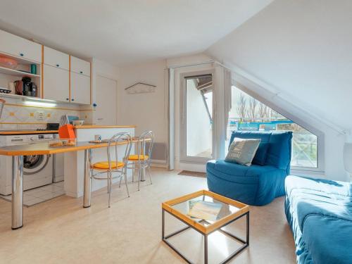 un salon avec un canapé bleu et une table dans l'établissement Studio cosy à Carnac, proche plages, avec balcon, parking, et équipements modernes pour 3 personnes - FR-1-477-45, à Carnac