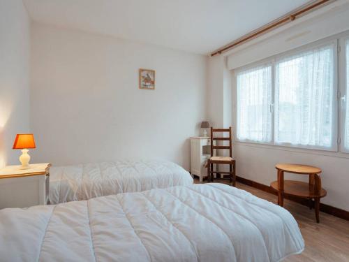 カルナックにあるAppartement 3P 69m² à mi-chemin plage et bourg de Carnac - FR-1-477-130のベッドが2つと大きな窓がある寝室