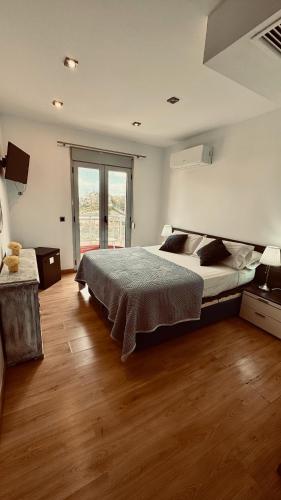 a bedroom with a large bed and a wooden floor at Red House Bed & breakfast in Llucmajor