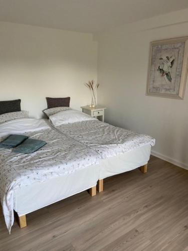 a bedroom with a large bed with white sheets at Overnatning Egsmark in Ebeltoft