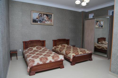 マハチカラにあるInn Kavkazのベッドルーム1室(ベッド2台、鏡付)