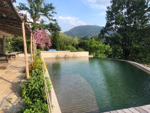 a swimming pool in a backyard with mountains in the background at Agriturismo Voeuja Lago Maggiore in Luino