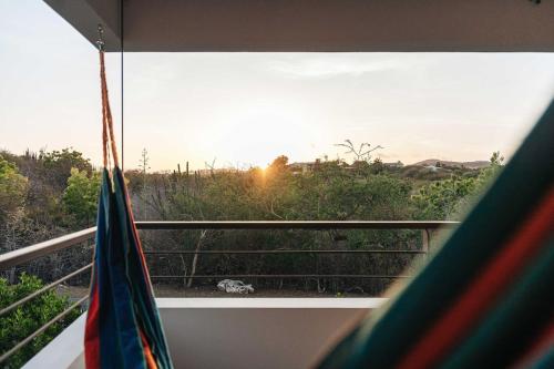 a view of the sunset from a balcony with a flag at 2BR LXRY Jansofat tropic oasis apt & pool in Willemstad