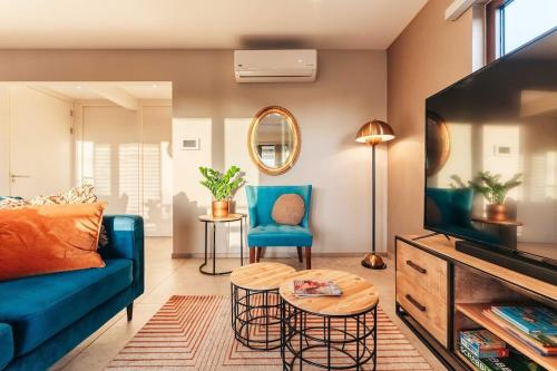 a living room with a blue couch and chairs at 2BR LXRY Jansofat tropic oasis apt & pool in Willemstad