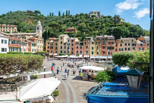 a group of people walking around a town with buildings at JOIVY Dreamlike Apartment in Piazzetta Portofino in Portofino