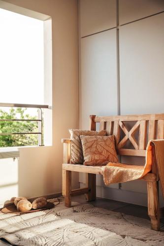 a wooden bench in a room with a window at 2BR LXRY Jansofat tropic oasis apt & pool in Willemstad