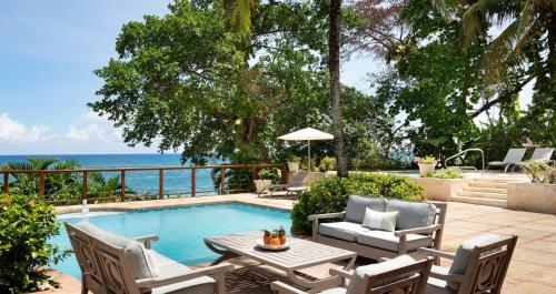 a patio with a table and chairs next to a swimming pool at Sandals Royal Plantation All Inclusive - Couples Only in Ocho Rios
