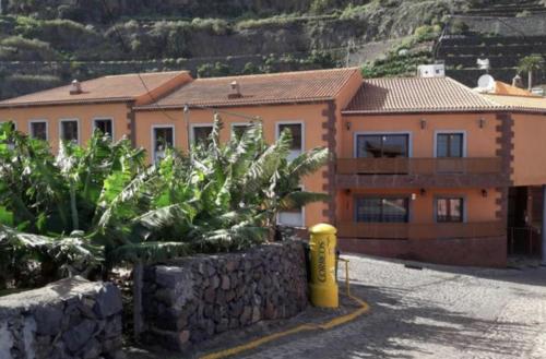 a yellow fire hydrant in front of a building at VV Telemaco Green in Agulo