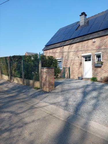 a brick building with solar panels on the roof at Villa à la campagne in Wanze