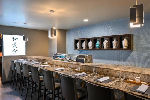 a bar in a restaurant with a row of stools at Sandals Halcyon Beach All Inclusive - Couples Only in Vigie