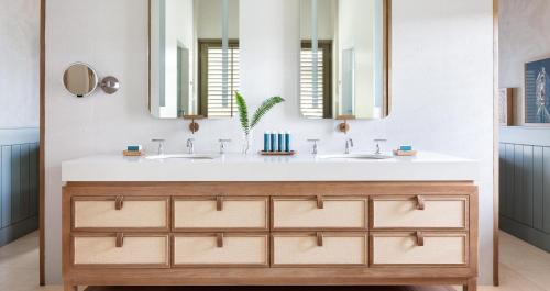 a bathroom with two sinks and a large mirror at Sandals Halcyon Beach All Inclusive - Couples Only in Vigie