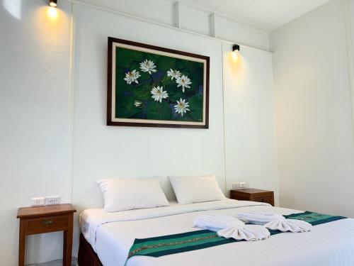 a bedroom with a bed with two towels on it at 3B Boutique Hotel in Chiang Mai