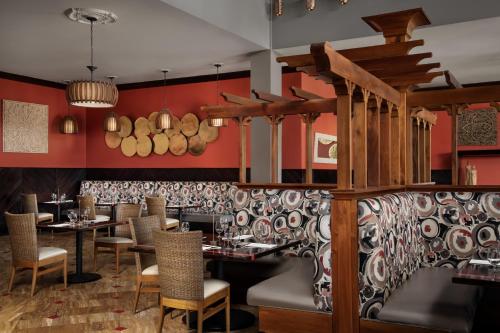a restaurant with red walls and tables and chairs at Sandals South Coast All Inclusive - Couples Only in Savanna-la-Mar