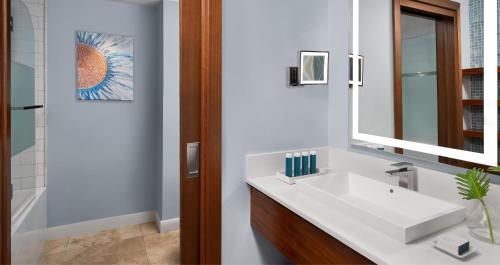 a bathroom with a white sink and a mirror at Sandals South Coast All Inclusive - Couples Only in Savanna-la-Mar