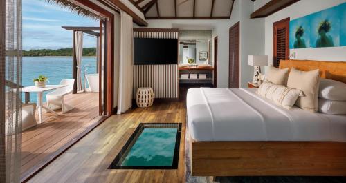 a bedroom with a bed and a view of the ocean at Sandals South Coast All Inclusive - Couples Only in Savanna-la-Mar