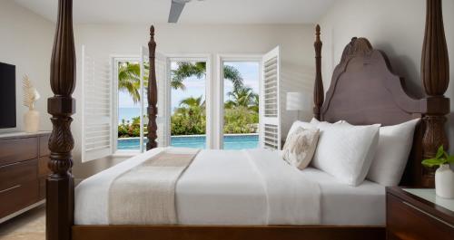 a bedroom with a bed and a view of the ocean at Sandals South Coast All Inclusive - Couples Only in Savanna-la-Mar