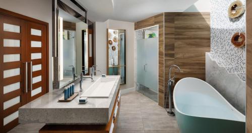 a bathroom with two sinks and a large mirror at Sandals South Coast All Inclusive - Couples Only in Savanna-la-Mar