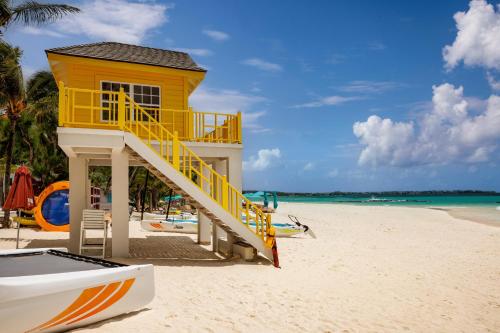 a yellow lifeguard house on a beach with a boat at Sandals Royal Barbados All Inclusive - Couples Only in Christ Church