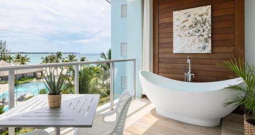 a bathtub on a balcony with a view of the ocean at Sandals Royal Barbados All Inclusive - Couples Only in Christ Church