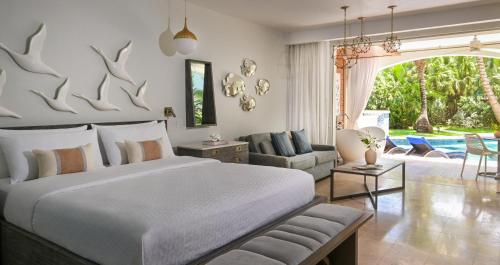 a bedroom with a large bed and a living room at Sandals Royal Barbados All Inclusive - Couples Only in Christ Church